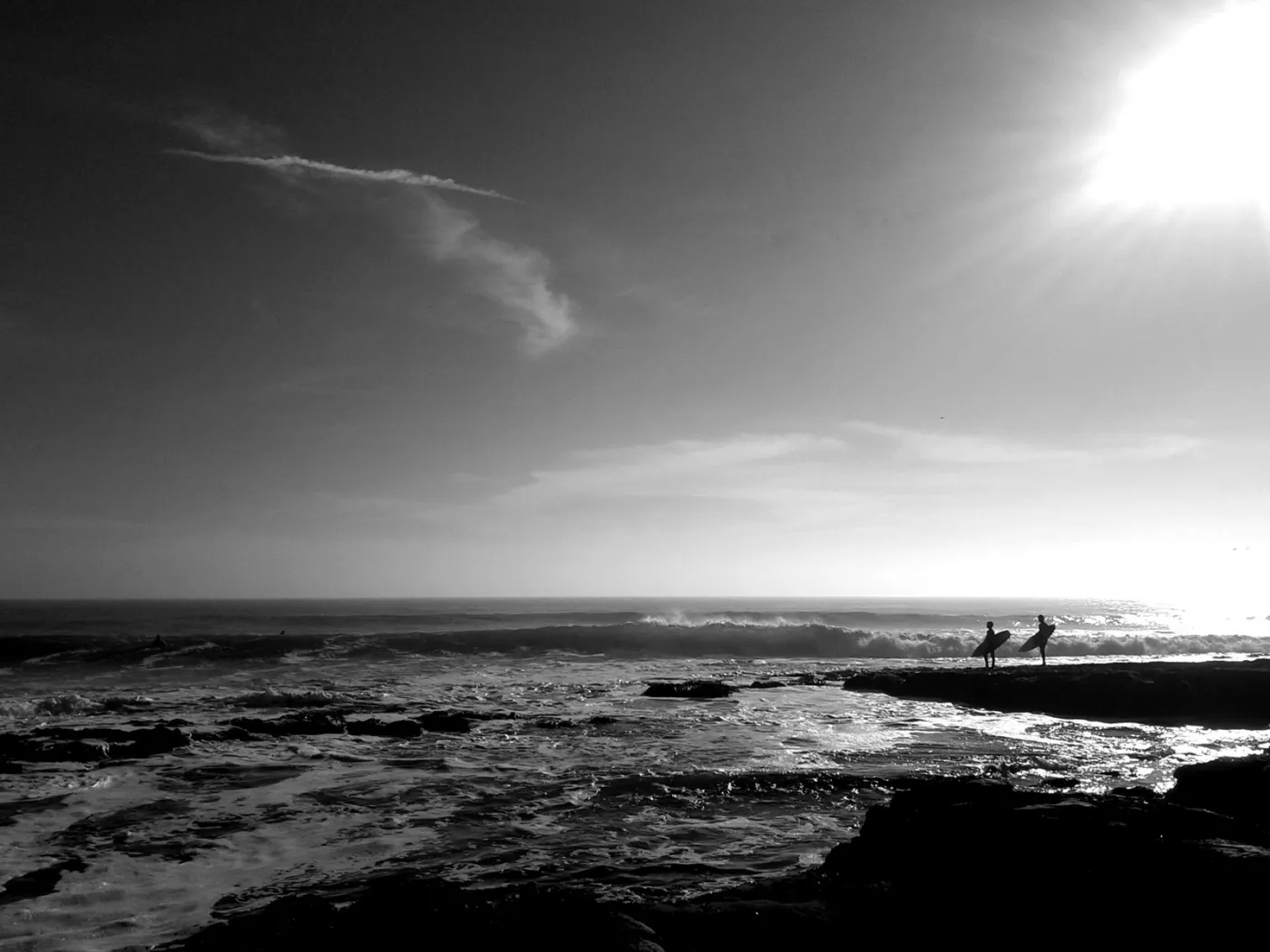 A black and white photograph of the shoreline at low tide