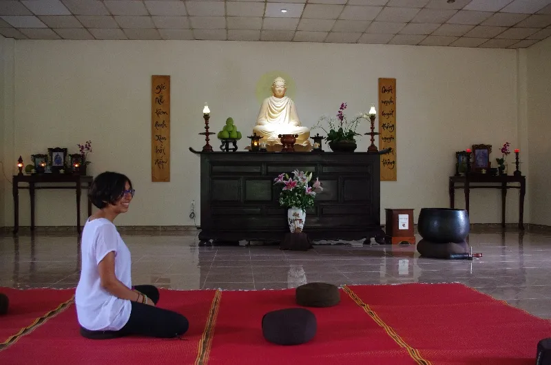 Nari kneeling before a shrine in a meditation hall