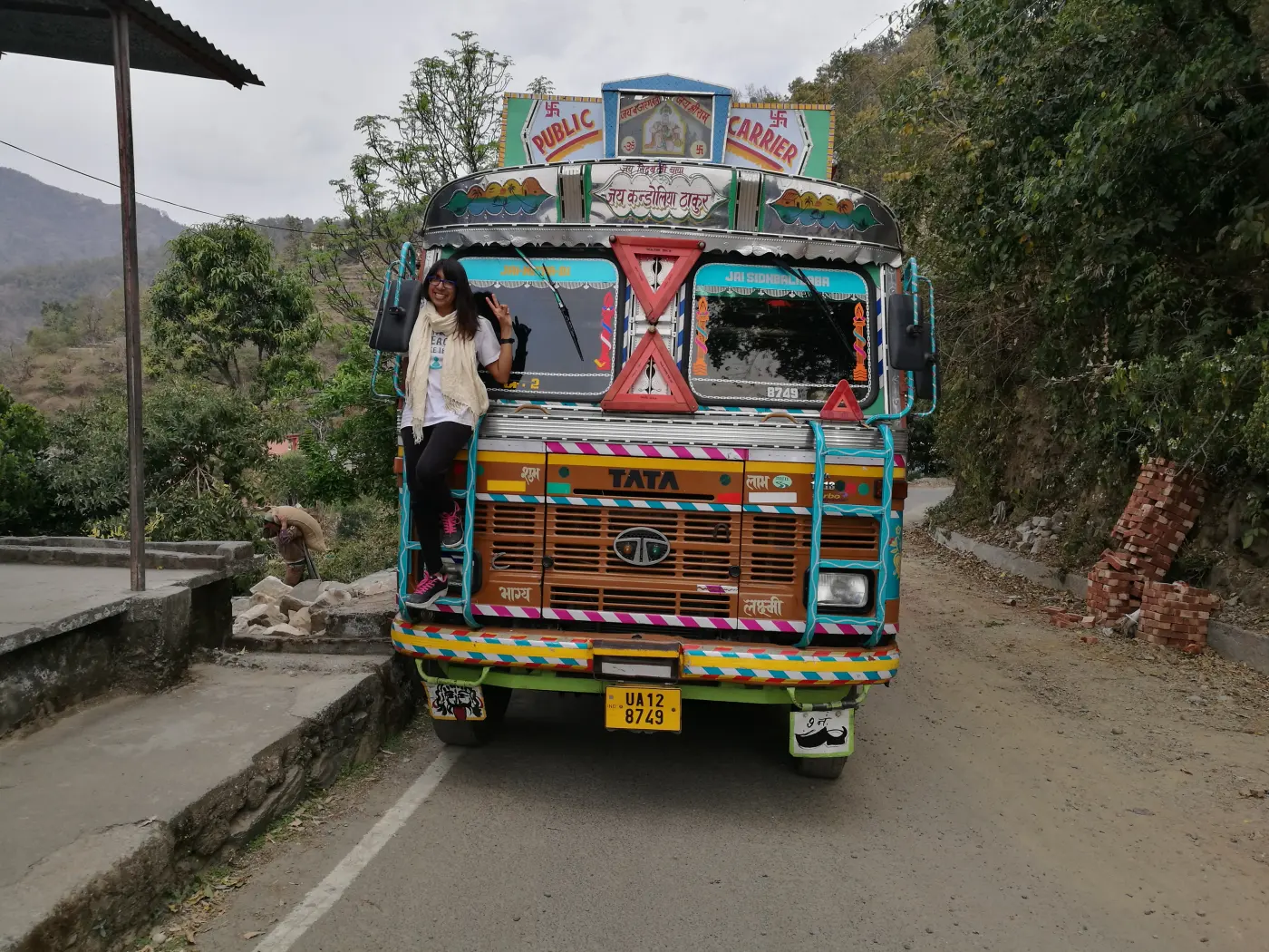 Narissa on the front of a hand-painted bus during her backpacking years