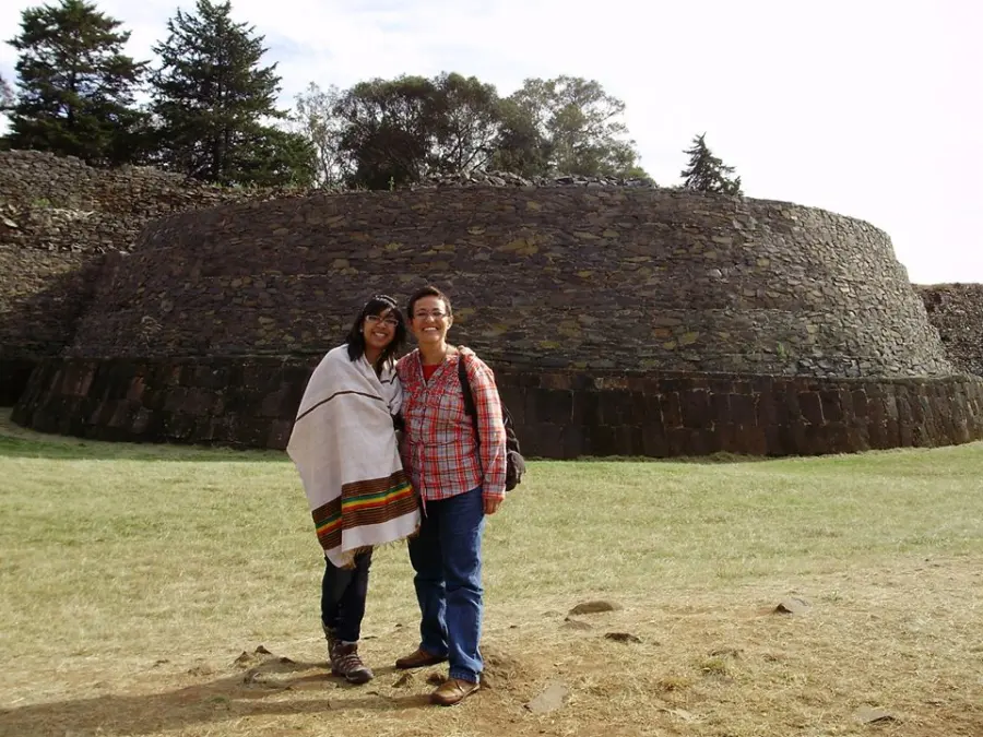 Nari with a local woman in front of stone ruins in Mexico