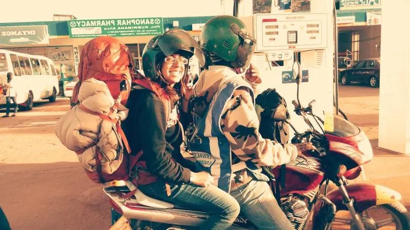 Nari riding pillion on a motorbike wearing a large backpack